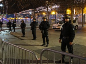 Police officers secure the  Stade de France stadium during the international friendly soccer France against Germany, Friday, Nov. 13, 2015 in Saint Denis, outside Paris. Two police officials say at least 11 people have been killed in shootouts and other violence around Paris. Police have reported shootouts in at least two restaurants in Paris. At least two explosions have been heard near the Stade de France stadium, and French media is reporting of a hostage-taking in the capital. (AP Photo/Michel Euler)